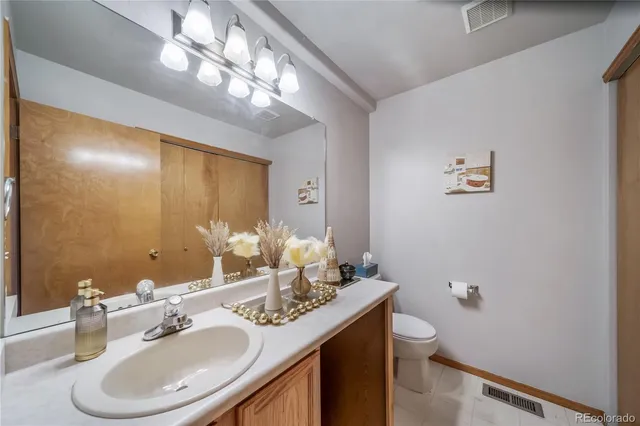 a bathroom with a sink a light fixture and a toilet