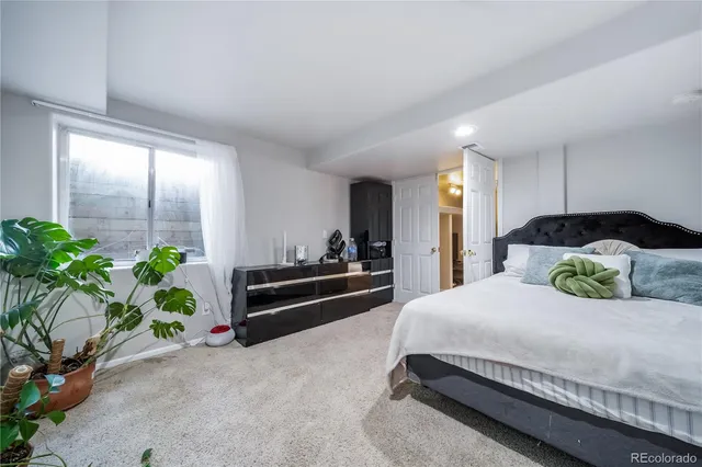 a bedroom with a bed and a potted plant