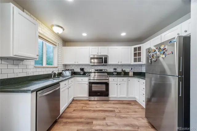 a kitchen with stainless steel appliances granite countertop a refrigerator sink and stove