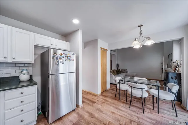 a kitchen with refrigerator a sink cabinets and wooden floor