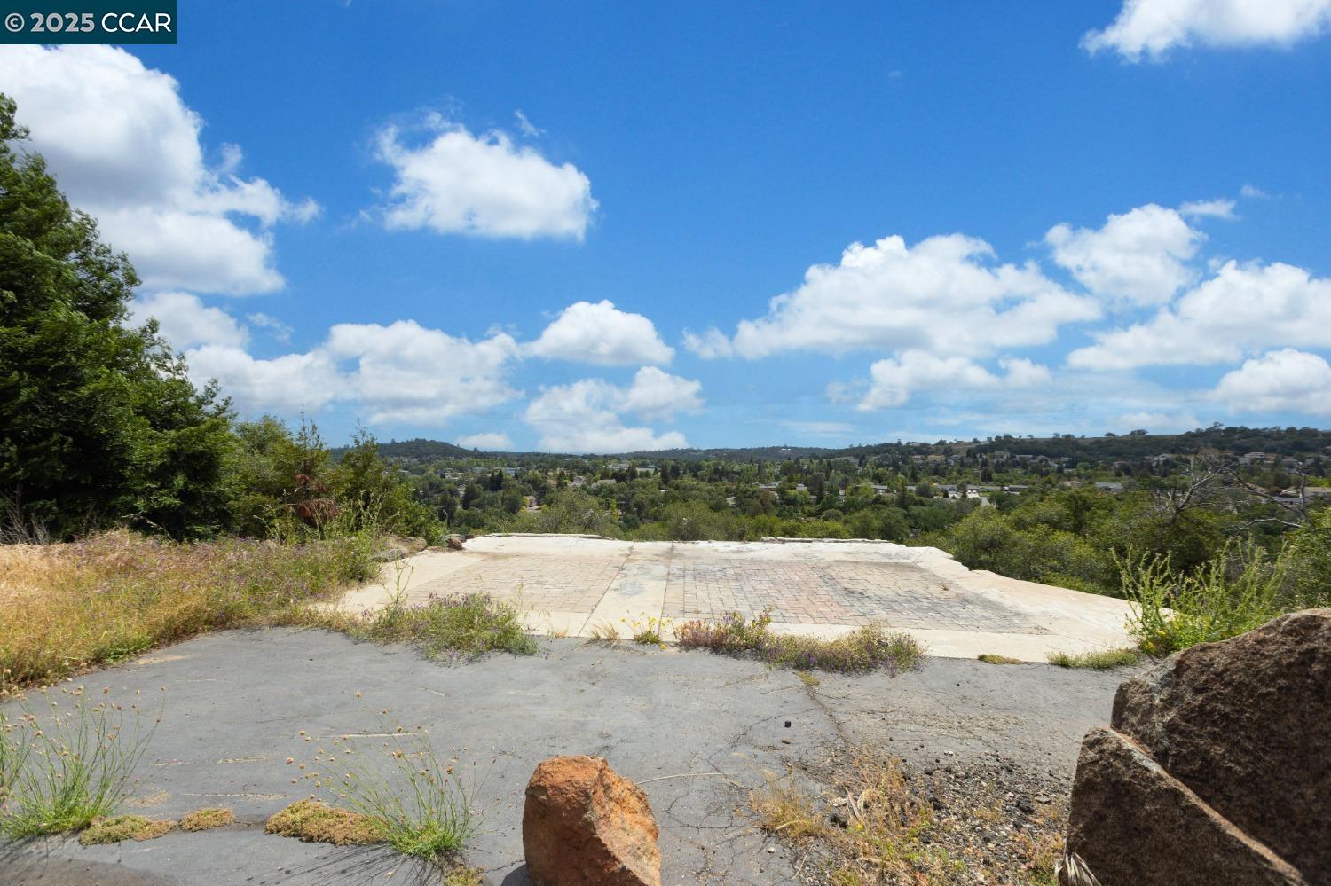 a view of a dry yard with wooden fence