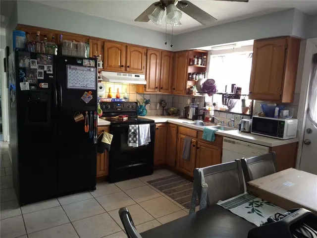 a kitchen with stainless steel appliances kitchen island granite countertop a refrigerator stove top oven and sink