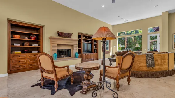 a living room with furniture fireplace and a large window