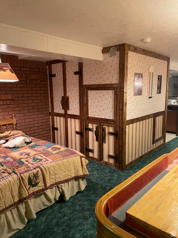 438 East Main Street Elsinore, UT 84724 - Photo 40 of 43 Finished space featuring a brick accent wall, wood-paneled structural elements, and plush green carpeting