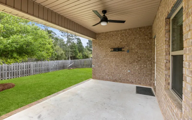 an empty room with a ceiling fan and windows