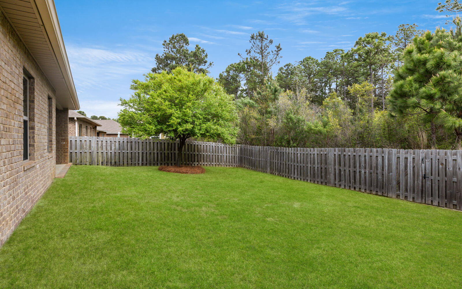 379 Whitman Way Freeport, FL 32439 - Photo 28 of 97 a view of a backyard with a trees and wooden fence