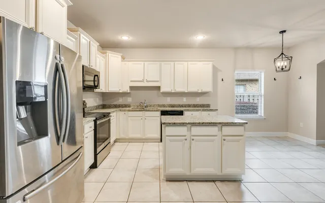 a kitchen with stainless steel appliances granite countertop a stove top oven a sink a counter top space and cabinets