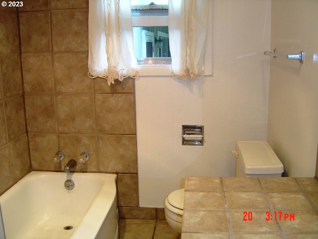 710 26th Street Springfield, OR 97477 - Photo 43 of 48 a bathroom with a tub a toilet and a window