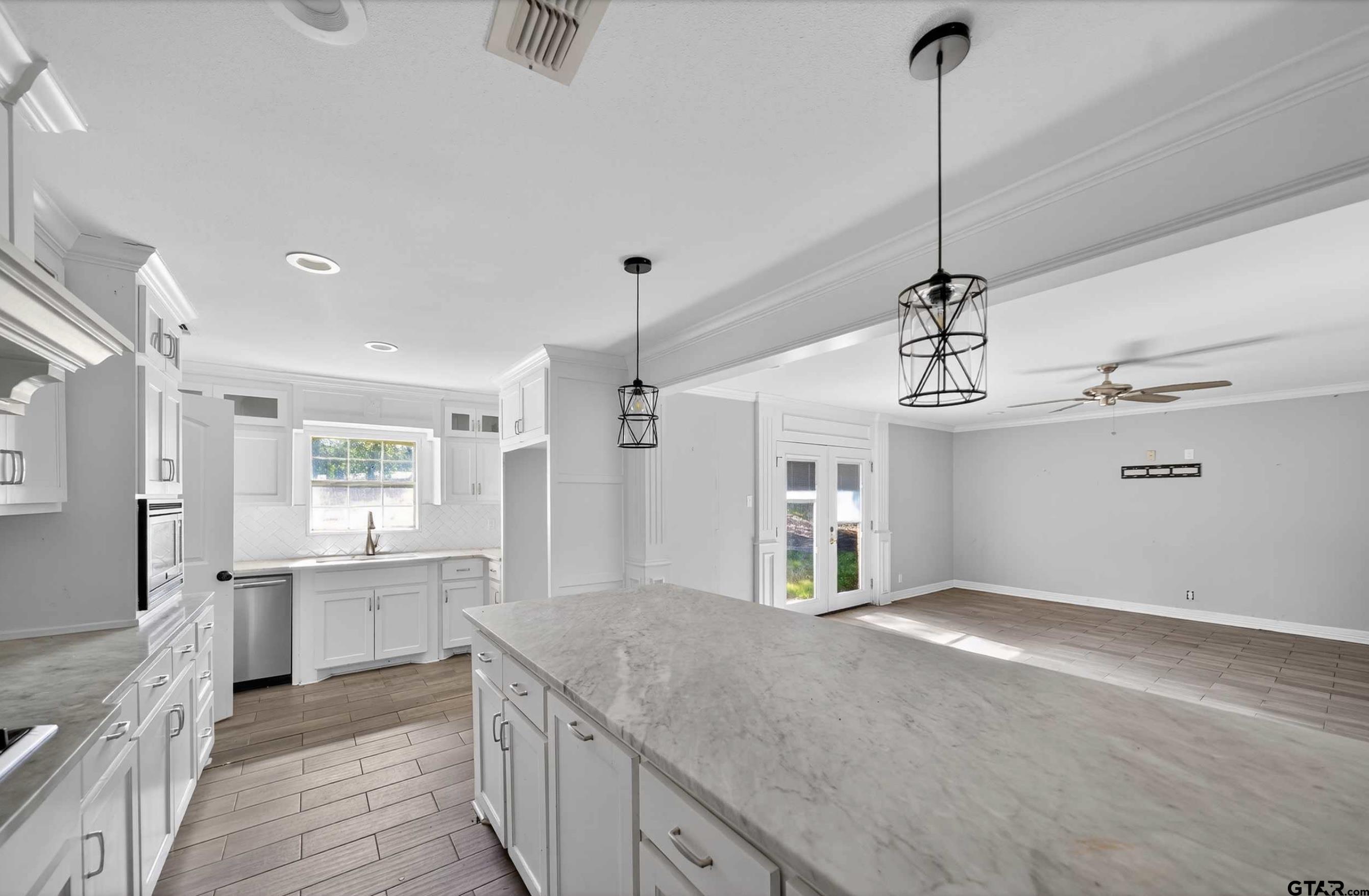 3408 Jackson Avenue Tyler, TX 75705 - Photo 16 of 45 a open kitchen with kitchen island white cabinets and refrigerator