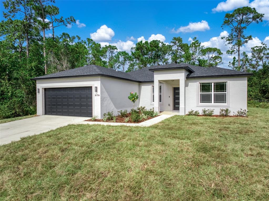 a view of a house with a yard and potted plants