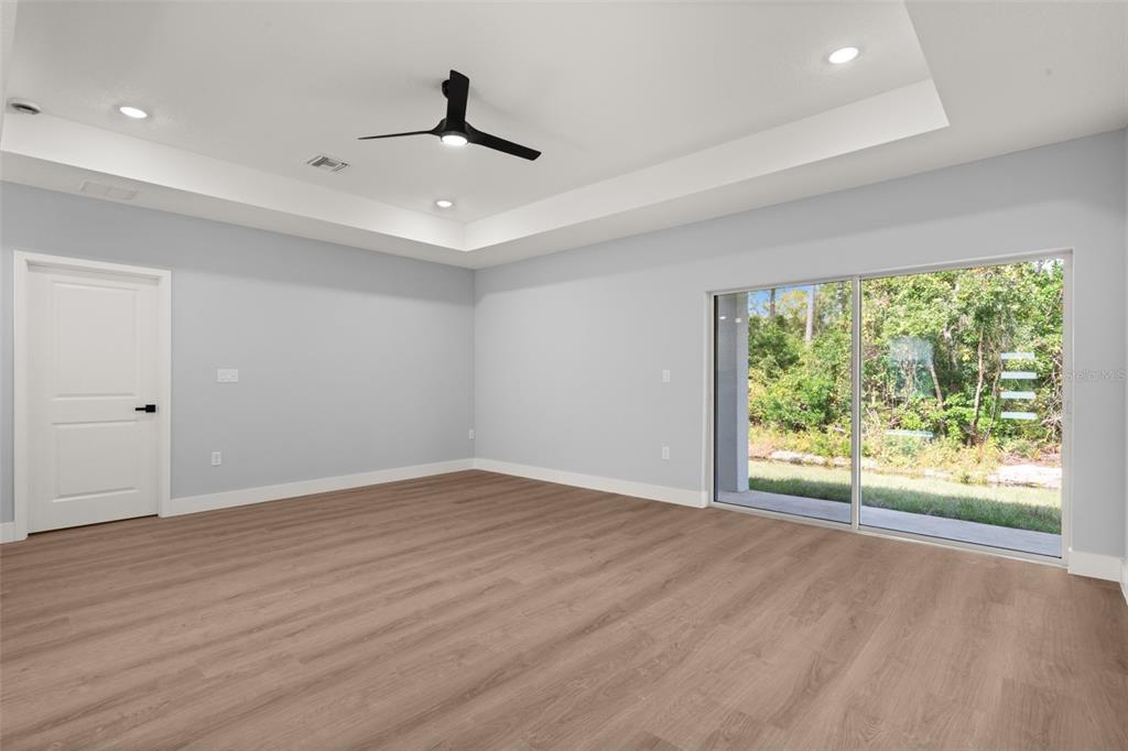 8736 Capilla Street Sebring, FL 33872 - Photo 13 of 60 a view of an empty room with wooden floor and a window