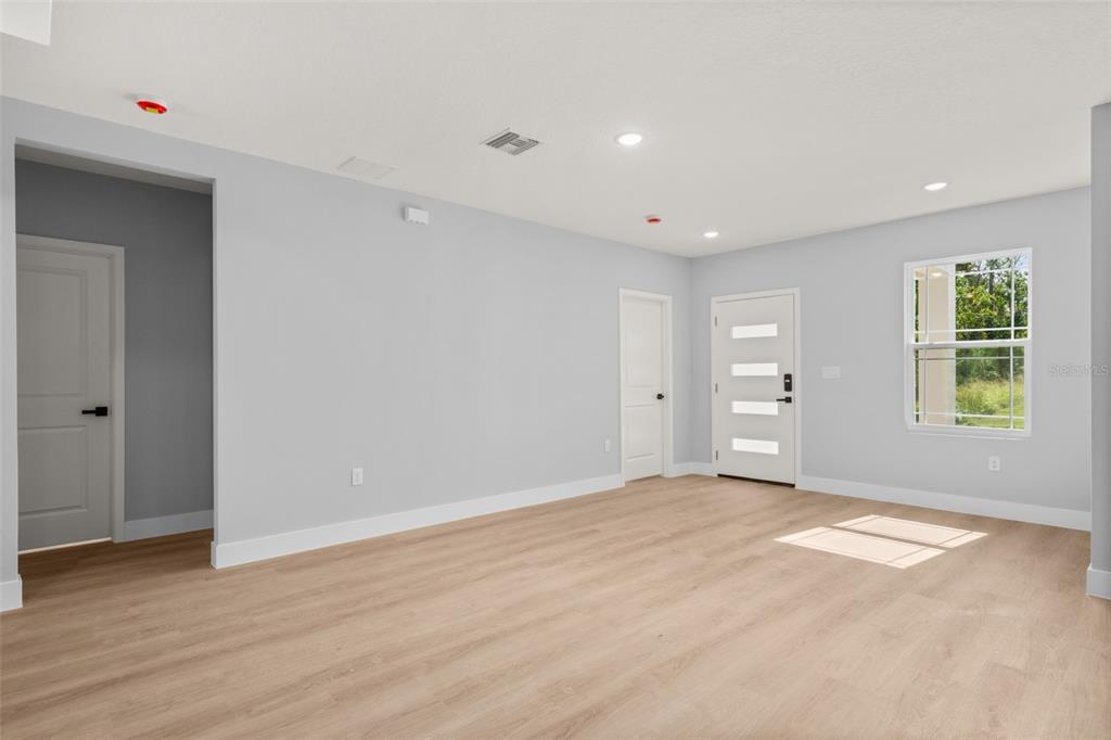 8736 Capilla Street Sebring, FL 33872 - Photo 9 of 60 a view of an empty room with wooden floor and a window