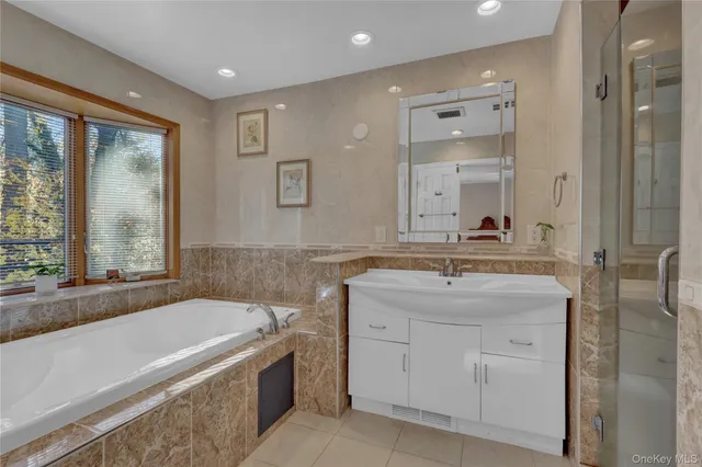 a bathroom with a granite countertop tub sink and mirror