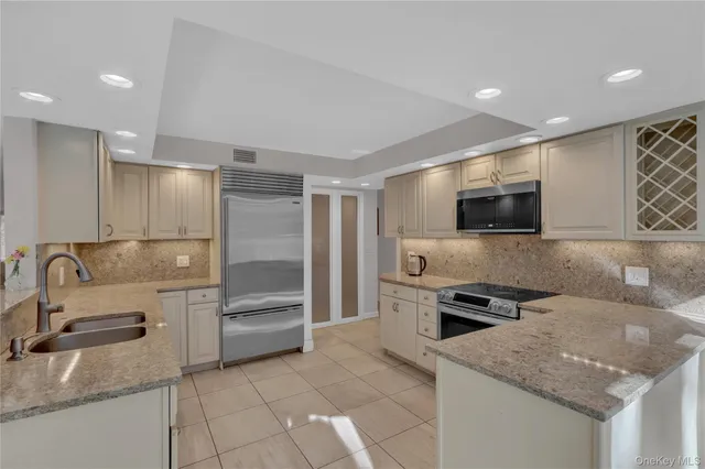 a kitchen with stainless steel appliances granite countertop a sink and a refrigerator