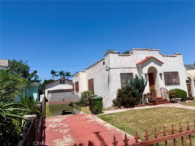 a view of a house with backyard and sitting area