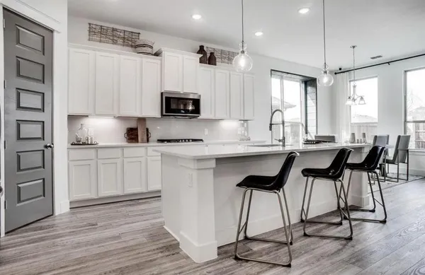 a kitchen with kitchen island granite countertop a sink cabinets and wooden floor