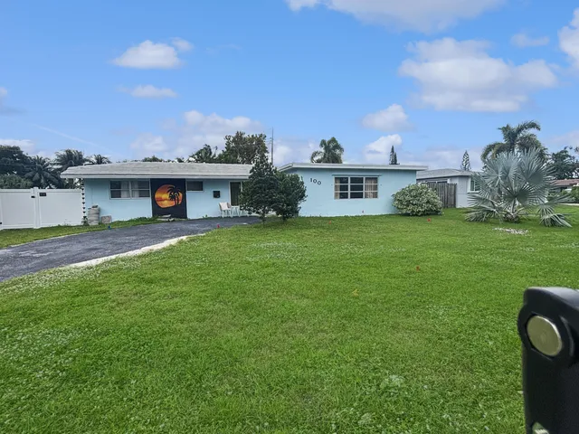 a view of a house with a yard and sitting area