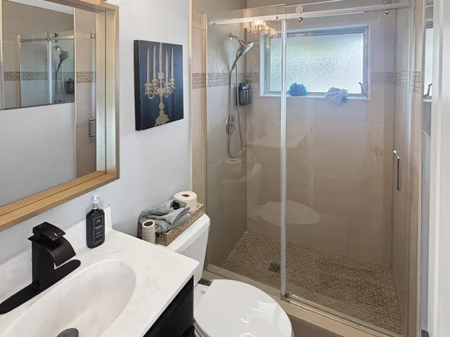 a bathroom with a sink toilet and shower
