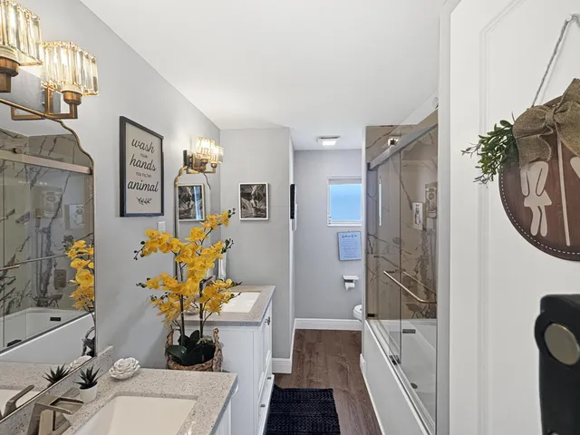 a bath room with a sink a couch and a potted plant