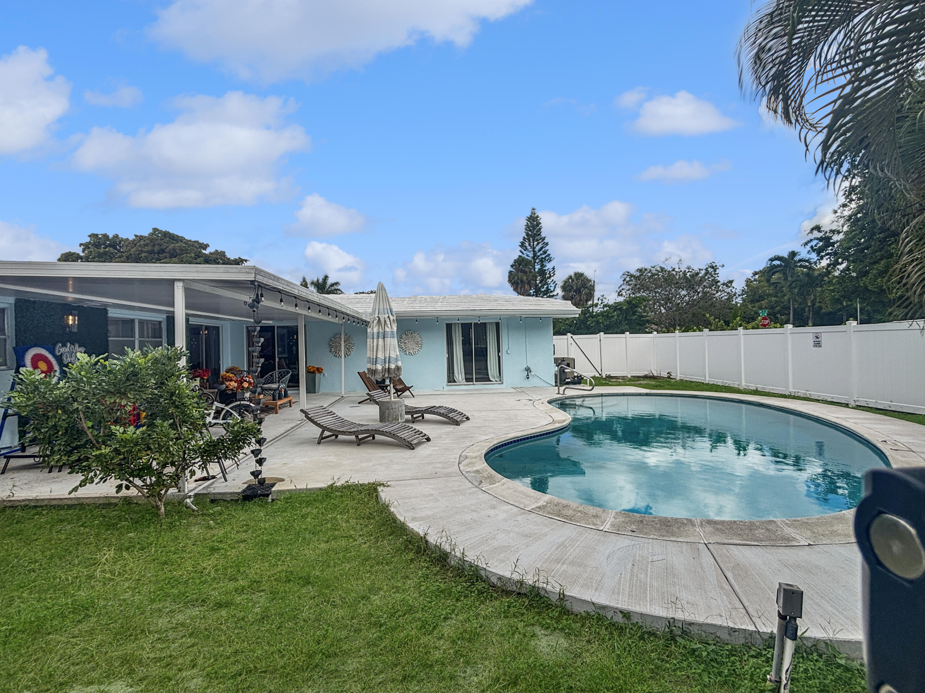 100 Southwest 17th Street Pompano Beach, FL 33060 - Photo 19 of 20 a view of swimming pool with outdoor seating and trees in the background
