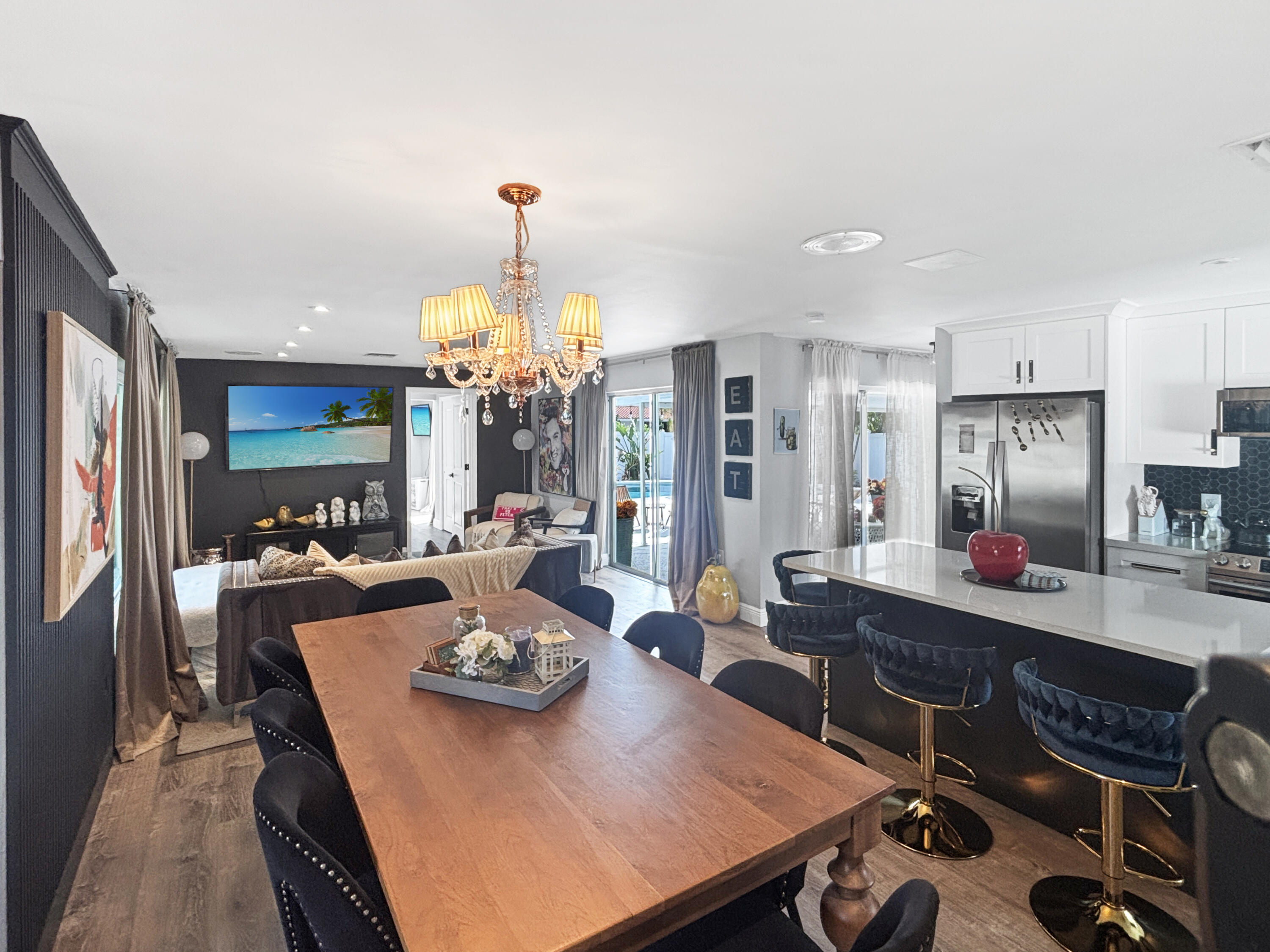 100 Southwest 17th Street Pompano Beach, FL 33060 - Photo 2 of 20 a view of a dining room and livingroom with furniture wooden floor a rug a fireplace and a chandelier