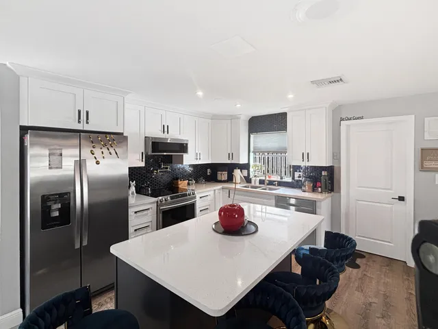 a kitchen with a sink a stove a refrigerator and cabinets