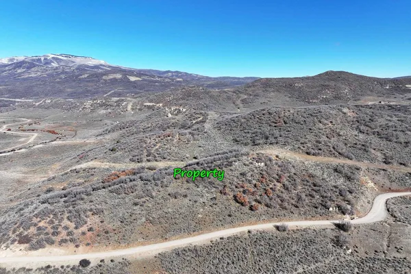 a view of a dry field with mountains in the background