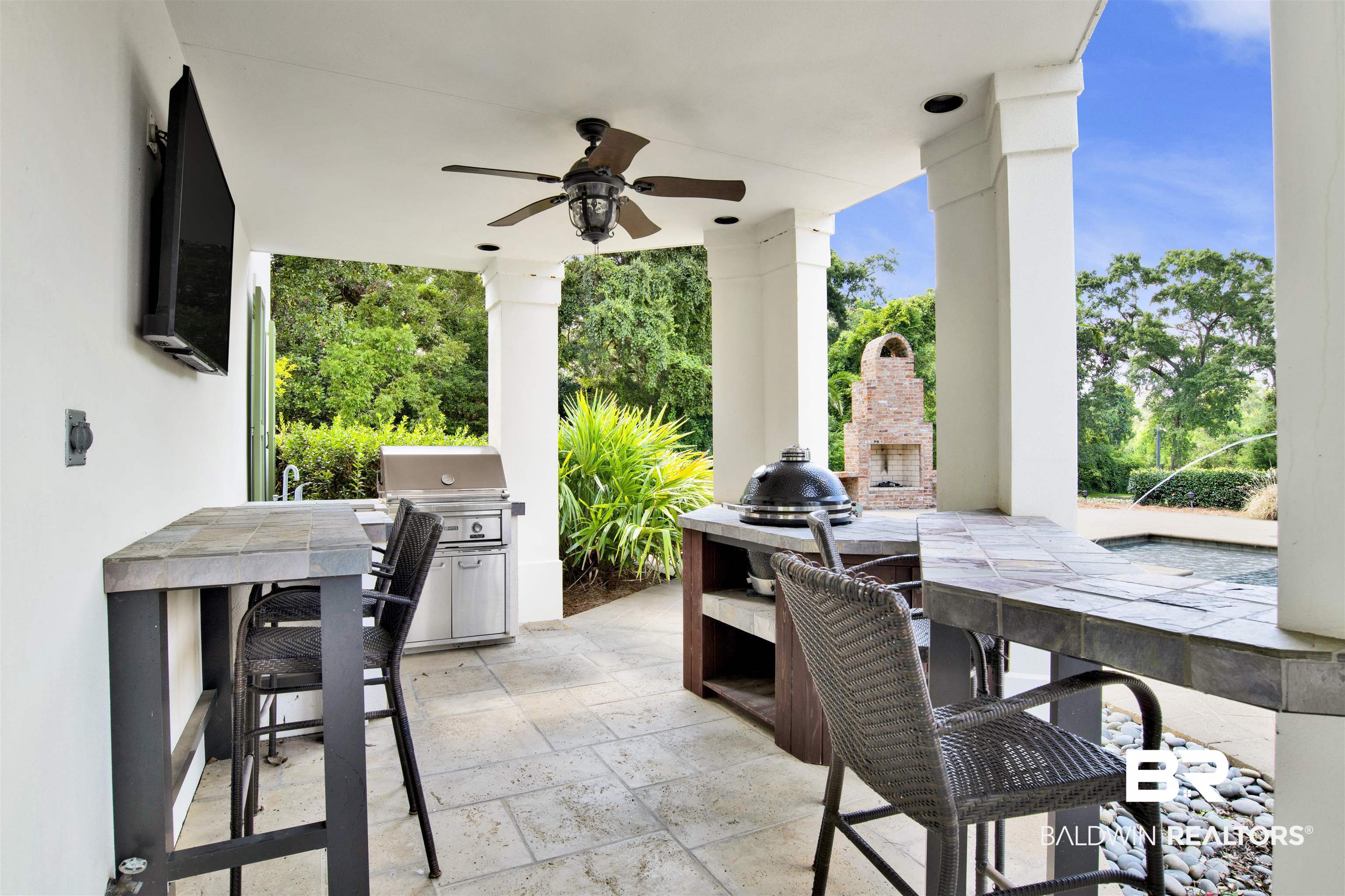 3816 Austill Lane Mobile, AL 36608 - Photo 58 of 80 View of patio / terrace with area for grilling, a ceiling fan, outdoor dining area, view of wooded area, and an outdoor fireplace