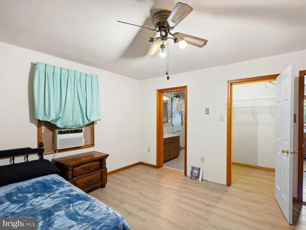 a bedroom with a bed a dresser and potted plants