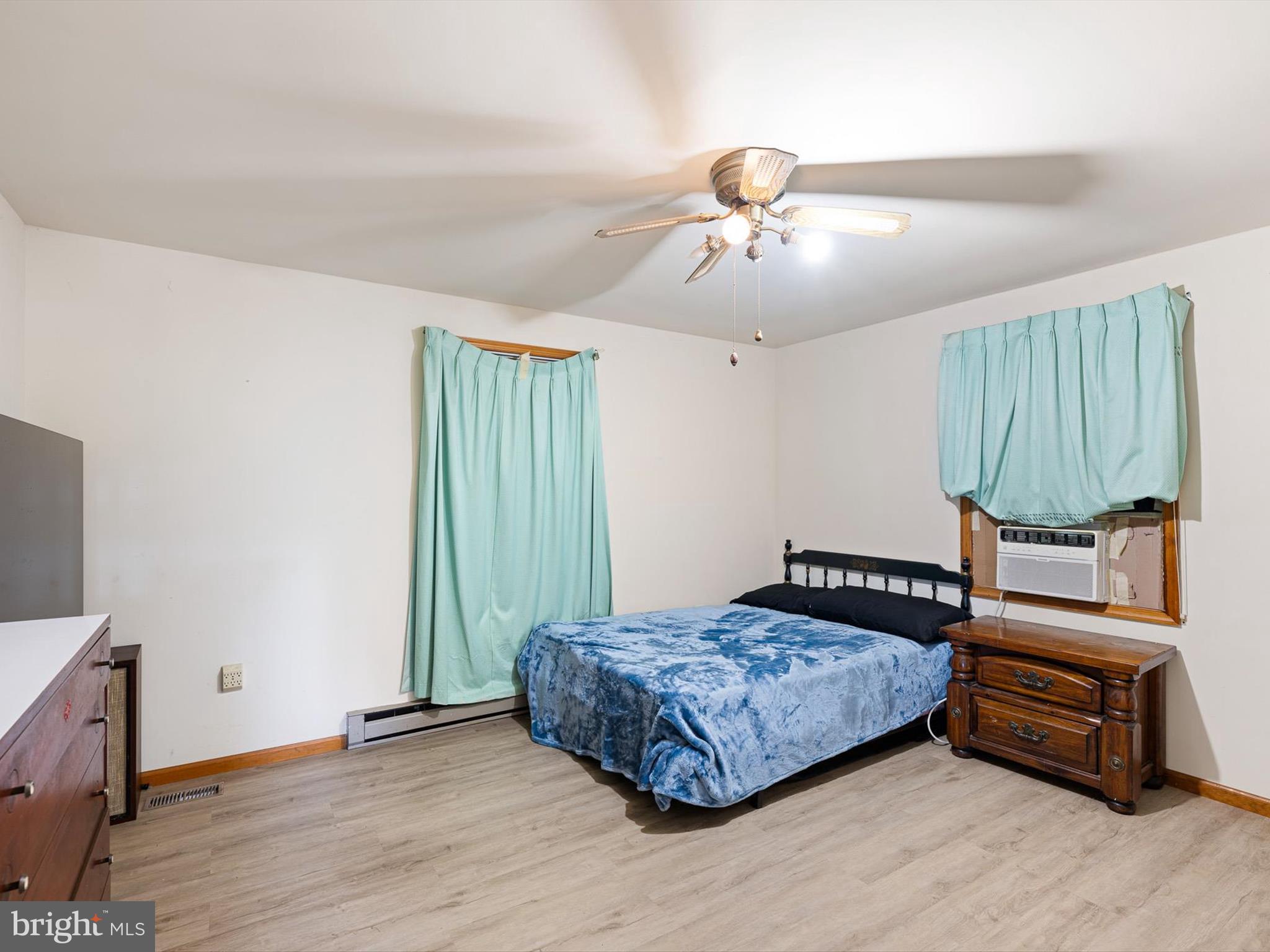 16327 Old Mill Road Lewes, DE 19958 - Photo 23 of 35 a bedroom with a bed a dresser and potted plants