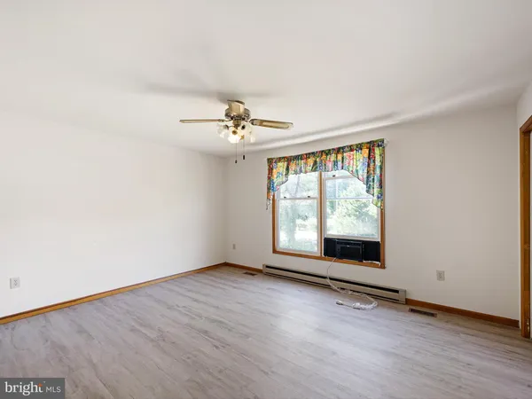 a view of a large pool with lawn chairs and large trees