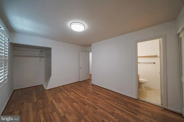 an empty room with wooden floor and closet