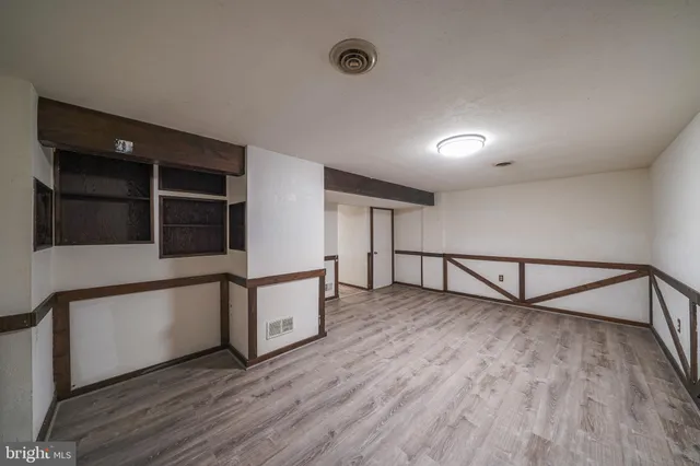 a view of a livingroom with an empty space and wooden floor