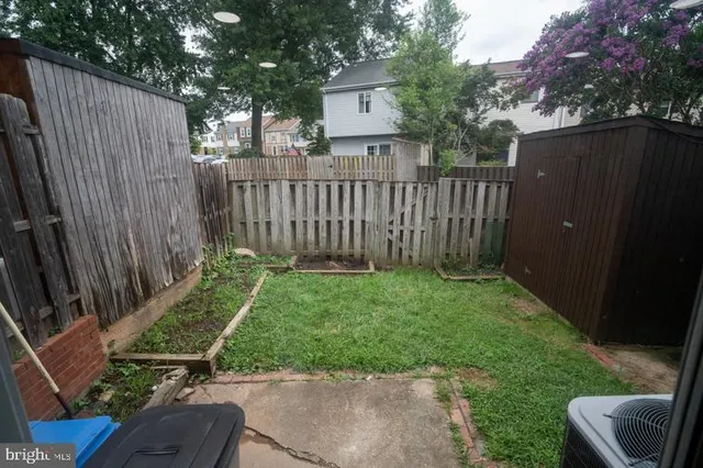 a view of a house with backyard and wooden fence