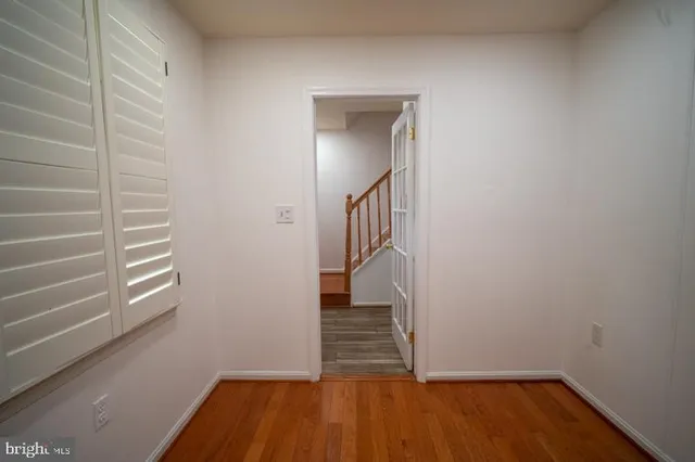 a view of a hallway with wooden floor and entryway