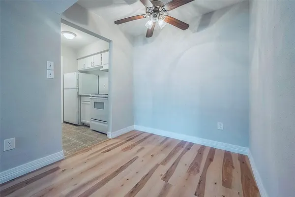 wooden floor in an empty room with a kitchen