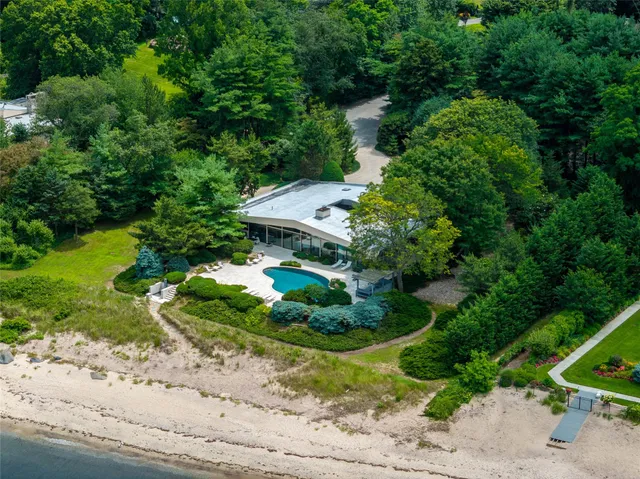 an aerial view of a house with a yard and greenery