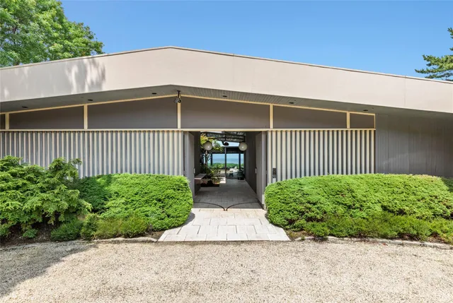 a front view of a house with a yard and plants