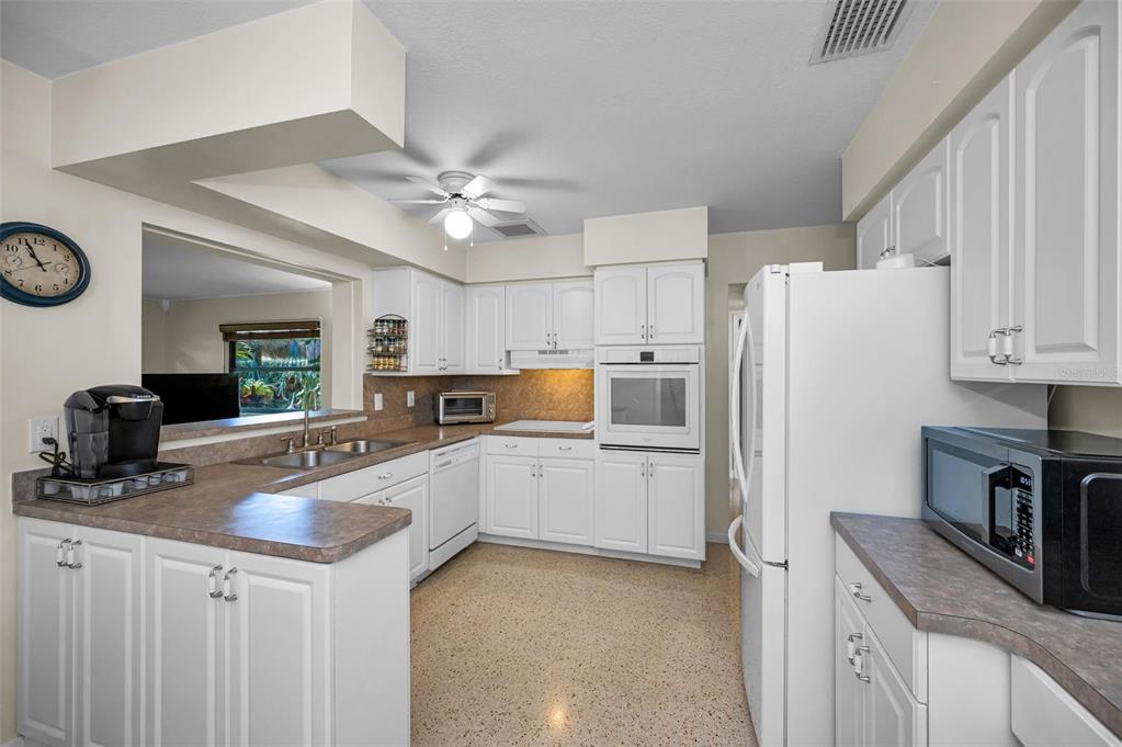 409 Graham Drive Clearwater, FL 33765 - Photo 26 of 75 a kitchen with a refrigerator a stove a sink and dishwasher with wooden floor