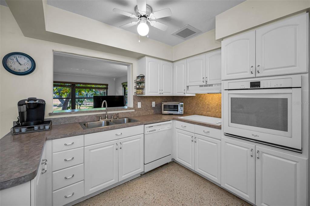 409 Graham Drive Clearwater, FL 33765 - Photo 27 of 75 a kitchen with cabinets stainless steel appliances a sink and a window