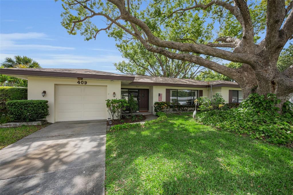 409 Graham Drive Clearwater, FL 33765 - Photo 8 of 75 a front view of a house with a garden and yard