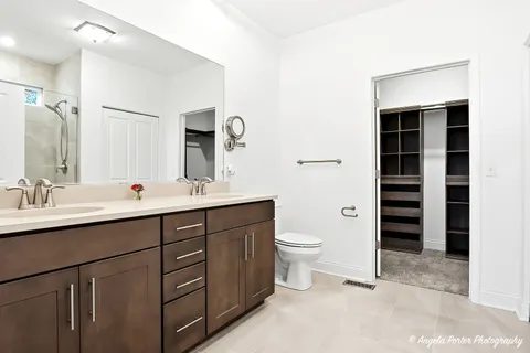 a bathroom with a double vanity sink a toilet and a mirror