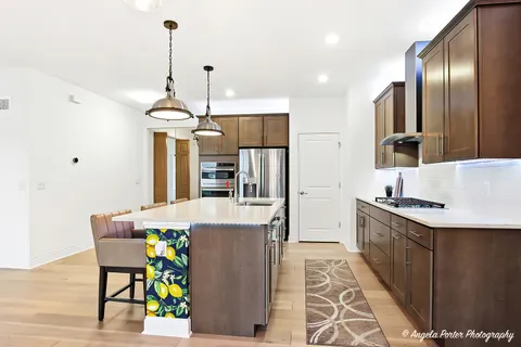 a kitchen with stainless steel appliances kitchen island granite countertop a refrigerator a sink and a stove