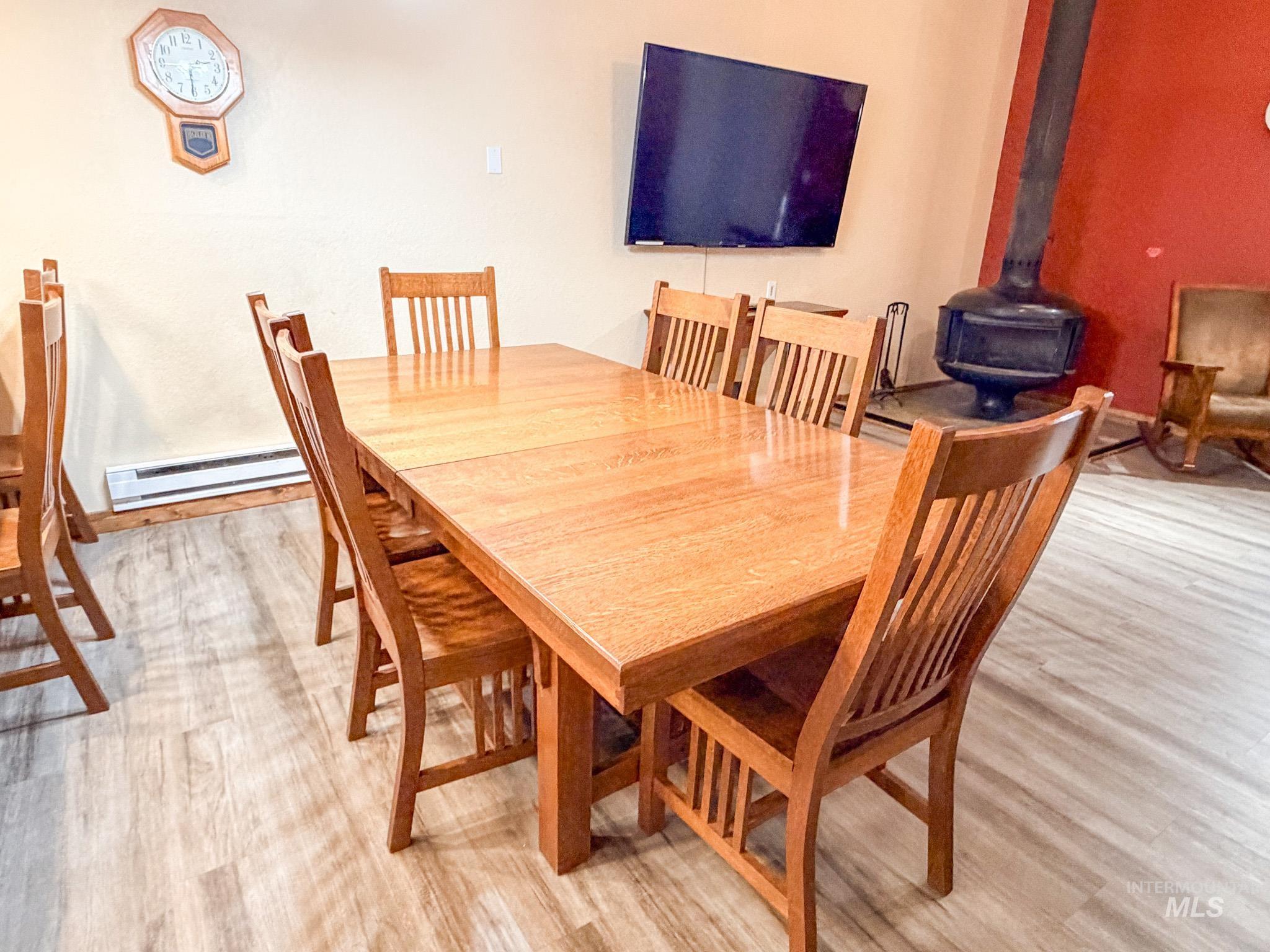 1630 Davis Avenue, Unit F46 McCall, ID 83638 - Photo 8 of 23 Dining room featuring a wood stove, a baseboard radiator, and light wood-type flooring