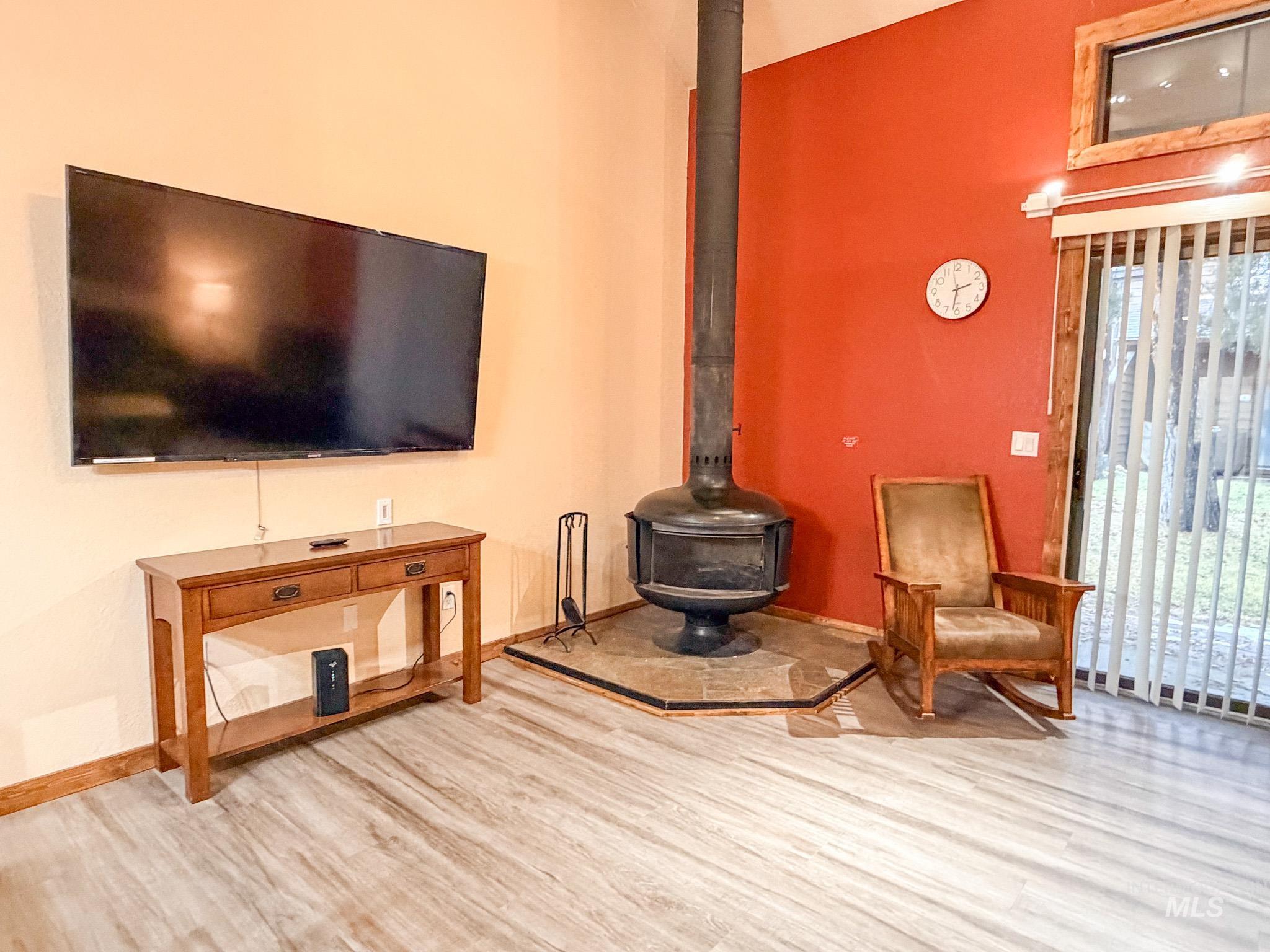 1630 Davis Avenue, Unit F46 McCall, ID 83638 - Photo 13 of 23 Living area featuring a wood stove, wood finished floors, and a towering ceiling