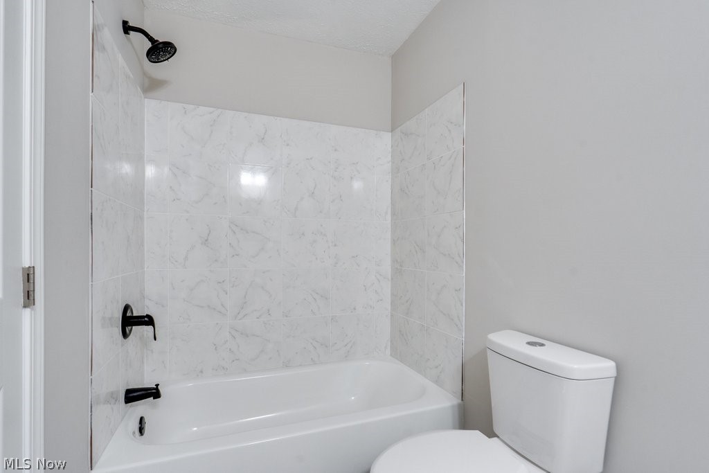 4596 Hattrick Road Rootstown, OH 44272 - Photo 40 of 45 Bathroom featuring tiled shower / bath, toilet, and a textured ceiling