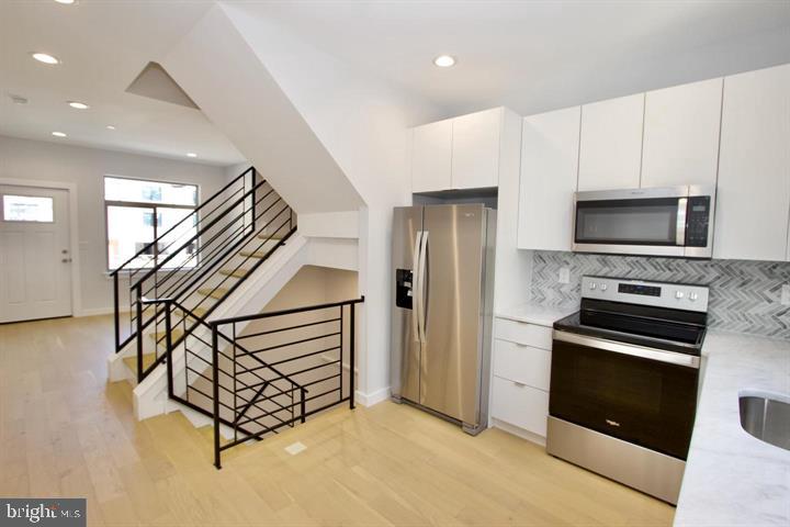 1608 North 3rd Street Philadelphia, PA 19122 - Photo 5 of 28 a kitchen with granite countertop a stove and a refrigerator