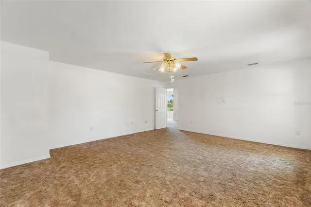 an empty room with a chandelier fan