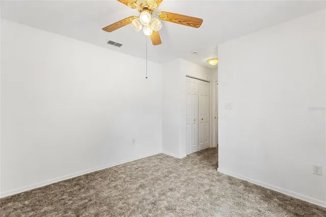 an empty room with a fan & a fan