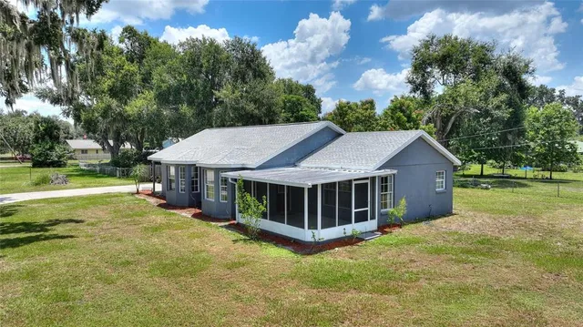 a view of a house with a yard balcony and tree